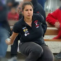 photo d'alexandra bornes qui pointe a la pétanque de manière accroupie